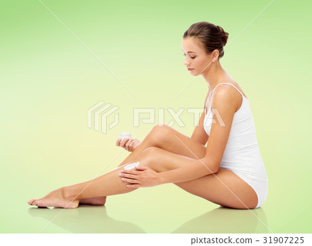 woman applying moisturizing cream to her leg woman applying moisturizing cream to her leg 31907225