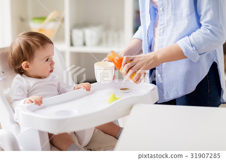 baby and mother pouring juice to cup at home baby and mother pouring juice to cup at home 31907285