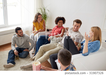 happy friends with popcorn and beer at home 31907326