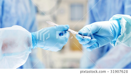 close up of hands with scalpel at operation 31907628