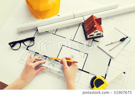 close up of hands with ruler measuring blueprint close up of hands with ruler measuring blueprint 31907675