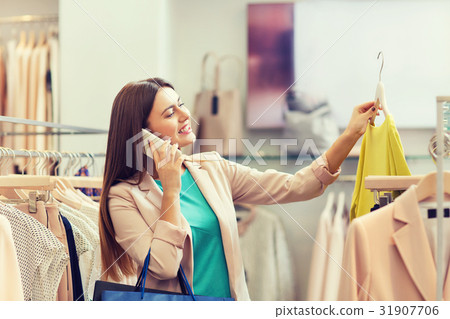 woman calling on smartphone at clothing store woman calling on smartphone at clothing store 31907706