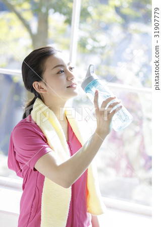 A woman with a bottle containing drinking water 31907779