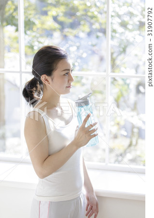 A woman with a bottle containing drinking water 31907792