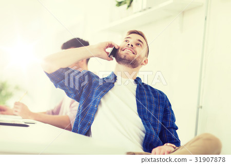 happy creative man calling on cellphone at office 31907878