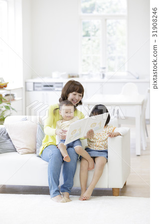 A mother reading a picture book to her daughters A mother reading a picture book to her daughters 31908246