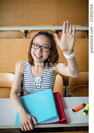 Young woman raising hand in classroom 31908368
