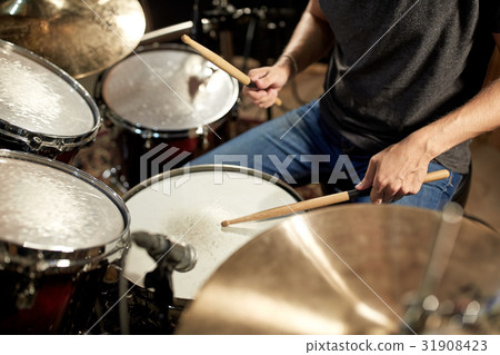 male musician playing drums and cymbals at concert 31908423