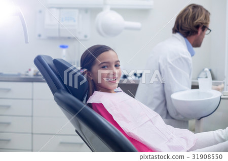 Smiling young patient sitting on dentists chair 31908550