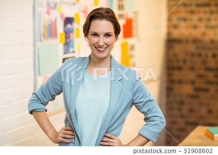 Portrait of businesswoman standing with hands on hips Portrait of businesswoman standing with hands on hips 31908602