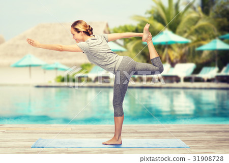 woman making yoga in lord of the dance pose on mat woman making yoga in lord of the dance pose on mat 31908728