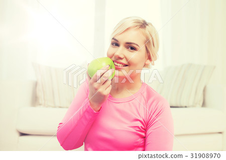 happy woman eating apple at home 31908970