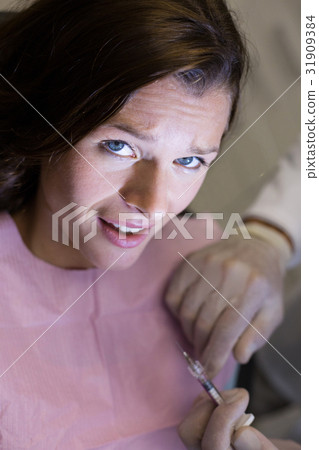 Dentist injecting female patient 31909384