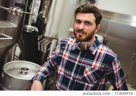 Confident manufacturer standing in brewery Confident manufacturer standing in brewery 31909459