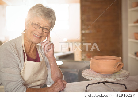 Female potter sitting at table Female potter sitting at table 31910227