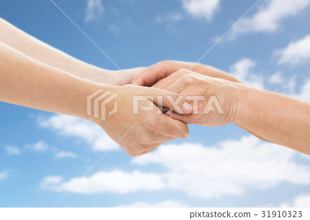 close up of senior and young woman holding hands 31910323