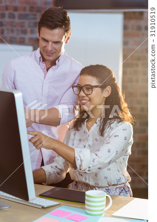 Businesswoman interacting with coworker while working on computer 31910519
