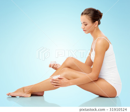 woman applying moisturizing cream to her leg woman applying moisturizing cream to her leg 31910524