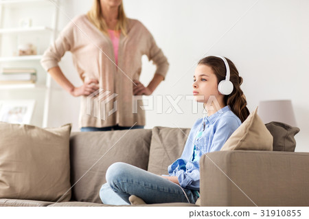 girl with earphones and angry mother at home 31910855