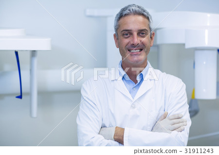 Smiling dentist standing in dental clinic Smiling dentist standing in dental clinic 31911243