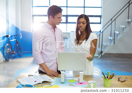 Business people discussing over laptop 31911250