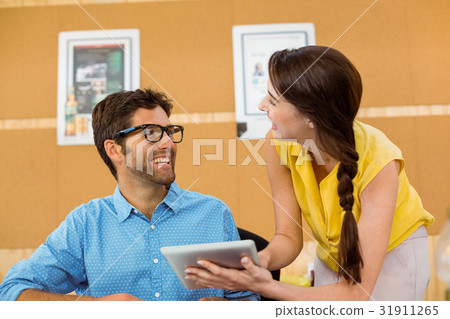 Business executive and co-worker interacting while using digital tablet 31911265
