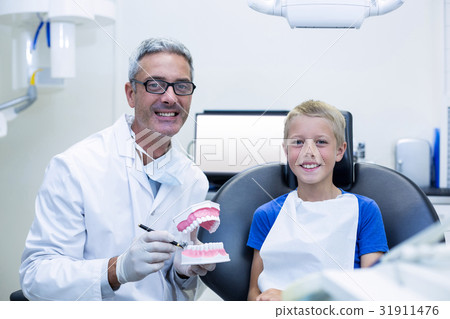 Portrait of smiling dentist and young patient 31911476
