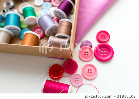 box with thread spools and sewing buttons on table box with thread spools and sewing buttons on table 31915102