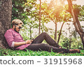 Hipster Man Resting and Playing Smartphone in Park 31915968