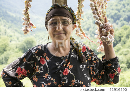 Portrait of an elderly woman picking dried garlic Portrait of an elderly woman picking dried garlic 31916390