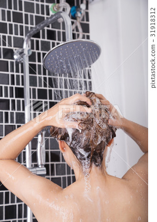 woman washing head and hair in the rain shower by shampoo, rear woman washing head and hair in the rain shower by shampoo, rear 31918312