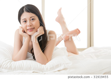 Asian young woman lying on bed comfortably Asian young woman lying on bed comfortably 31919455