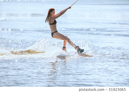 Woman in a bathing suit goes for wakeboarding. 31923065