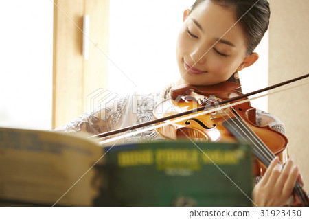 A woman playing a violin 31923450