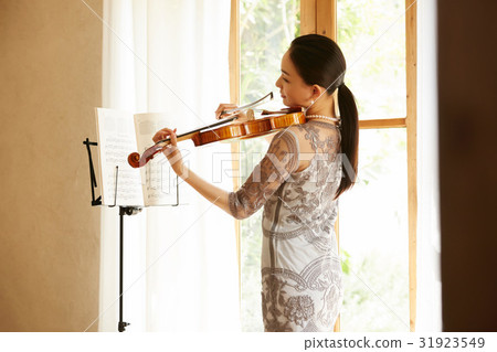 A woman playing a violin A woman playing a violin 31923549