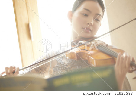 A woman playing a violin 31923588