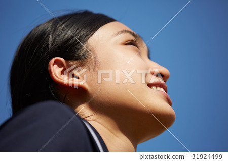 A girl looking up at the blue sky 31924499