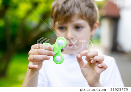 School kid playing with Tri Fidget Hand Spinner School kid playing with Tri Fidget Hand Spinner 31925779