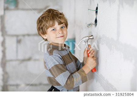 Little kid boy helping with toy tools on Little kid boy helping with toy tools on 31925804