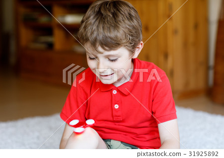 School kid playing with Tri Fidget Hand Spinner 31925892