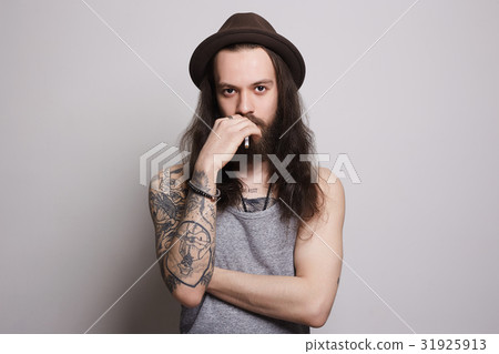 handsome bearded man is smoking and looking handsome bearded man is smoking and looking 31925913