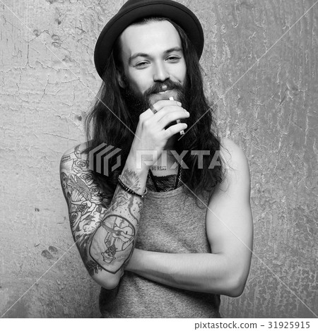 Smiling Hipster with tattoo and cigarette Smiling Hipster with tattoo and cigarette 31925915