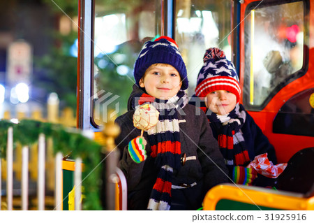 Two little kids boys on carousel at Christmas Two little kids boys on carousel at Christmas 31925916