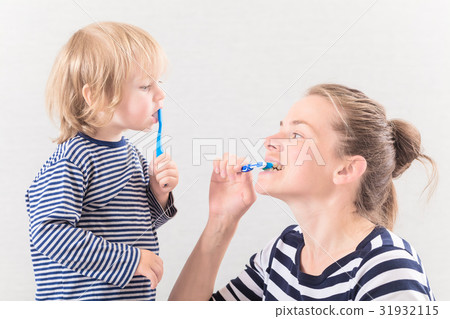 Mom with baby brushing teeth 31932115