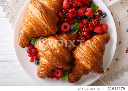 Golden croissants with fresh summer berries 31933379