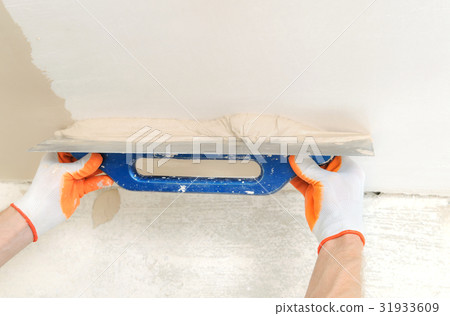 Worker's hands are plastering. Worker's hands are plastering. 31933609