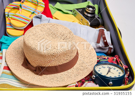 Woven hat, clothes in suitcase. 31935155
