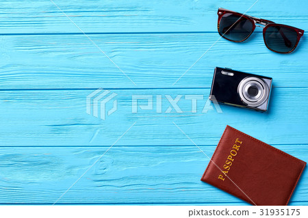 Glasses, camera, passport, wooden background. 31935175