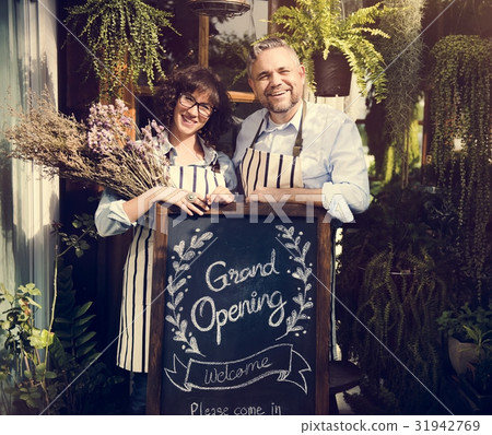 Adult Man and Woman Standing with Grand Opening Sign Adult Man and Woman Standing with Grand Opening Sign 31942769