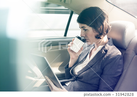 Businesswoman using digital tablet on backseat of the car 31942828